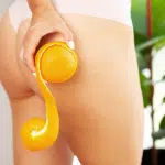 a woman's flawless butt while holding orange in her hand